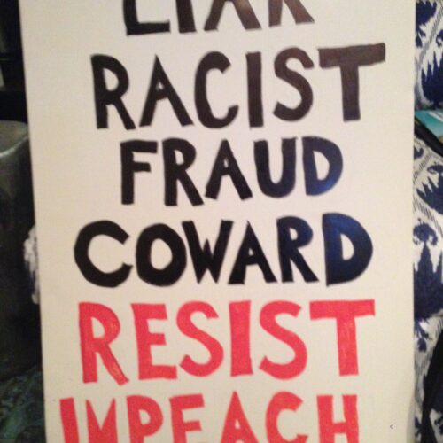 Protest sign reading LIAR RACIST FRAUD COWARD RESIST IMPEACH