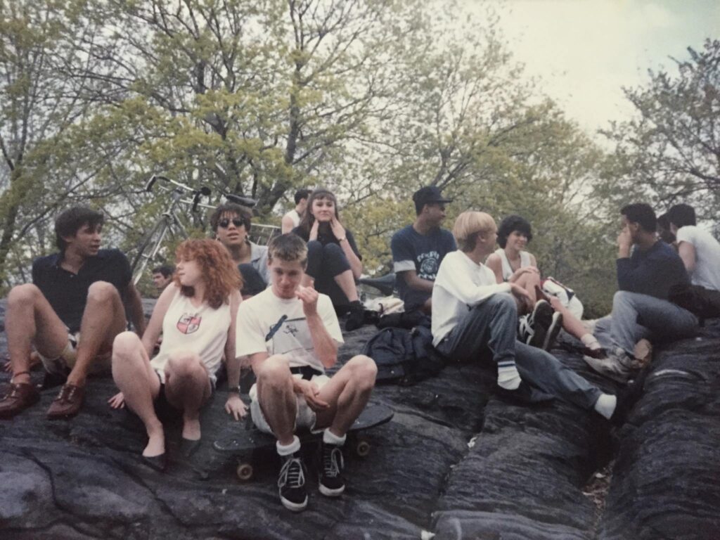 A group of teenagers sit on a rock formation in New York's Central Park, 1985