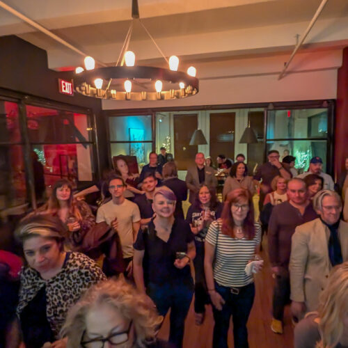 Crowd of sophisticated literary artistic types at a reading/party