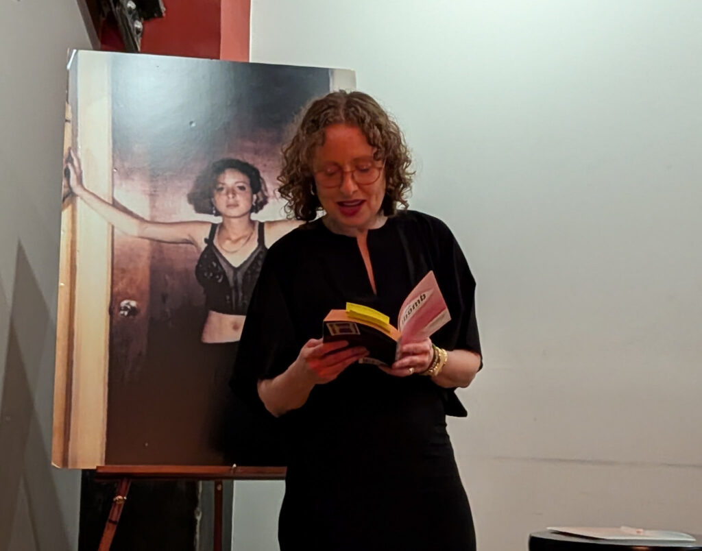 Janice, present day, reads in front of a picture of Janice, age 14