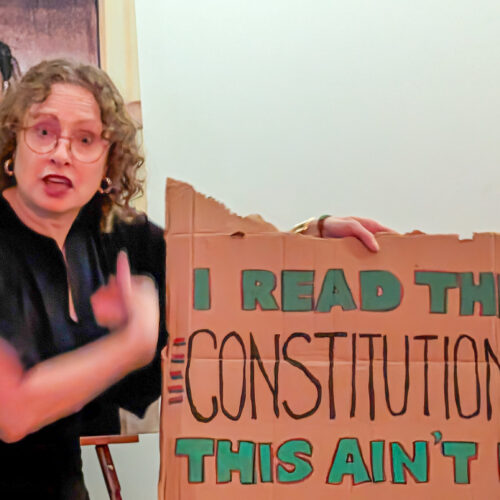 Janice holding No Kings protest sign reading I READ THE CONSTITUTION. THIS AIN'T IT.